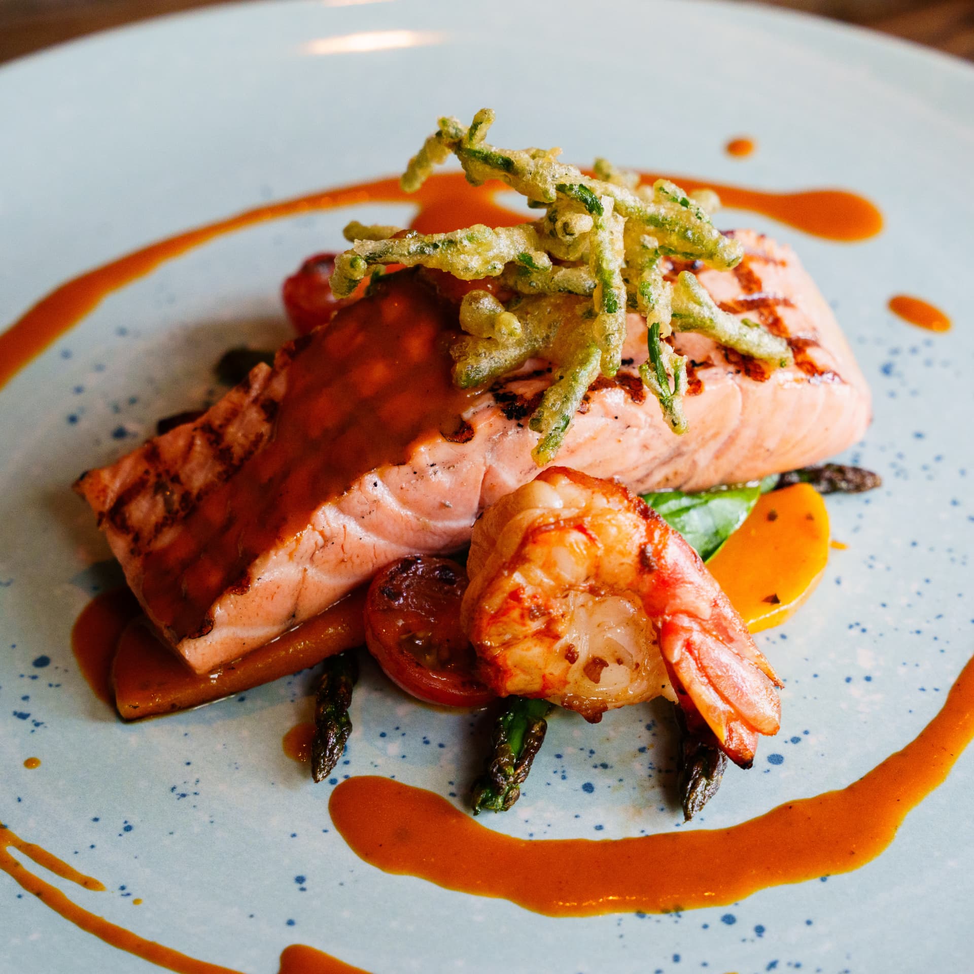 Pan-seared salmon with king prawn, asparagus and rich sauce