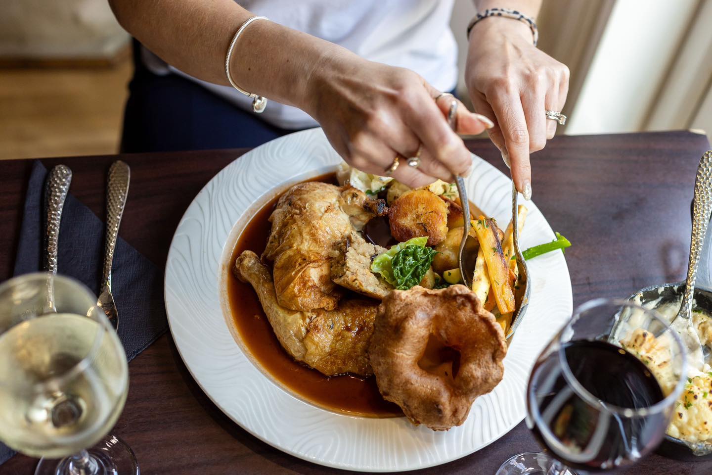 Guest carving a Sunday roast chicken dinner at La Luna, Talbot Green