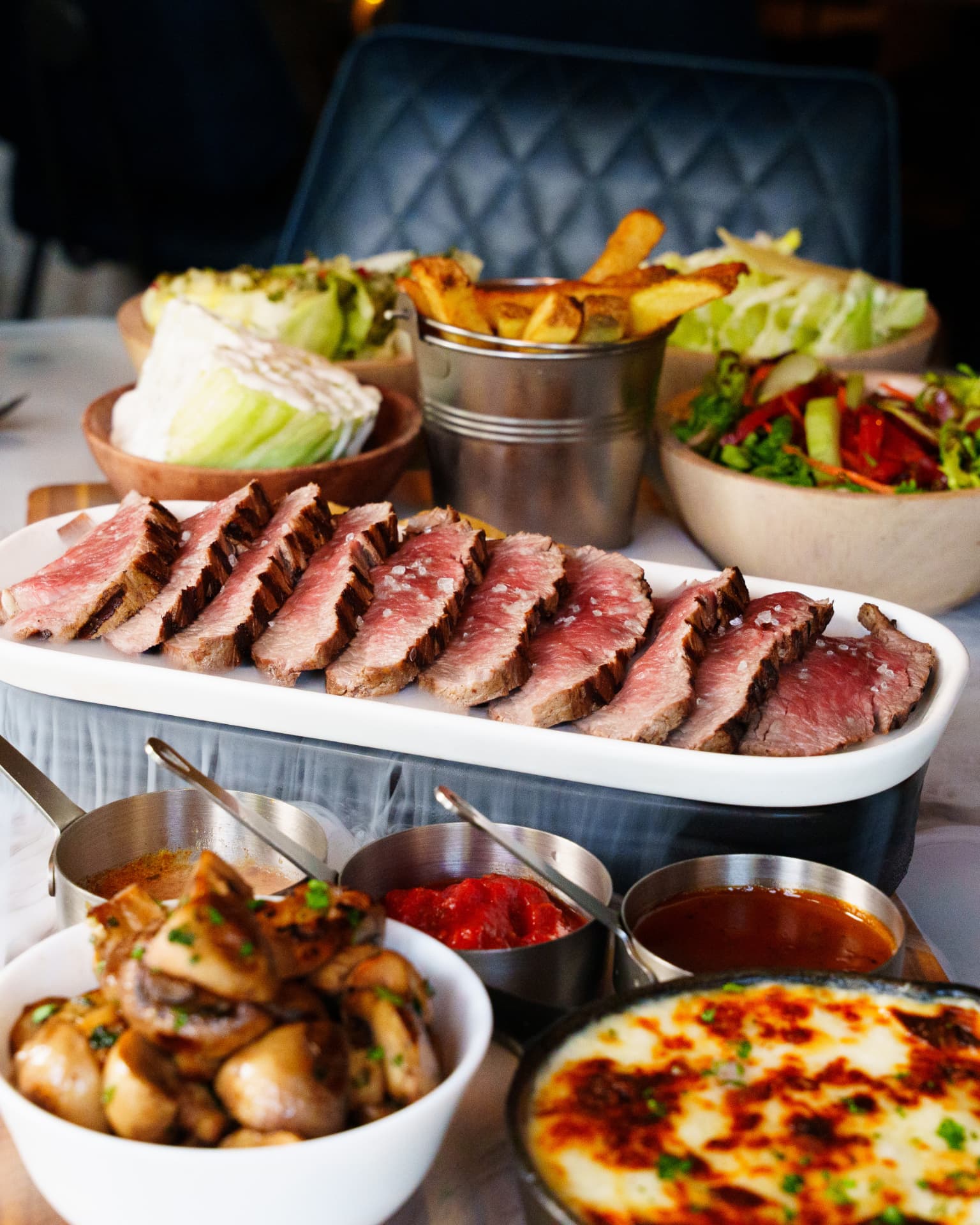 Sliced steak sharing board with sides and sauces, served in the La Luna restaurant, Talbot Green, near Pontyclun