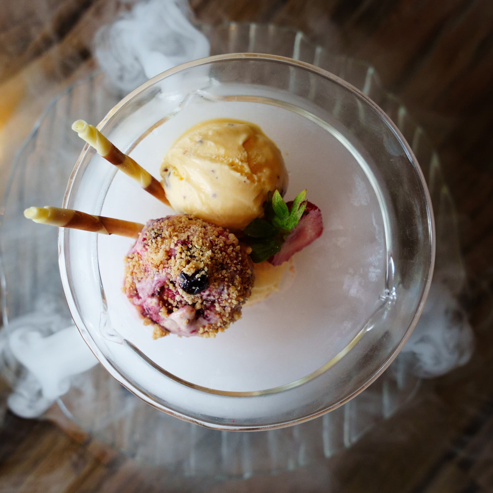 Dessert of ice cream, berry crumble and wafers