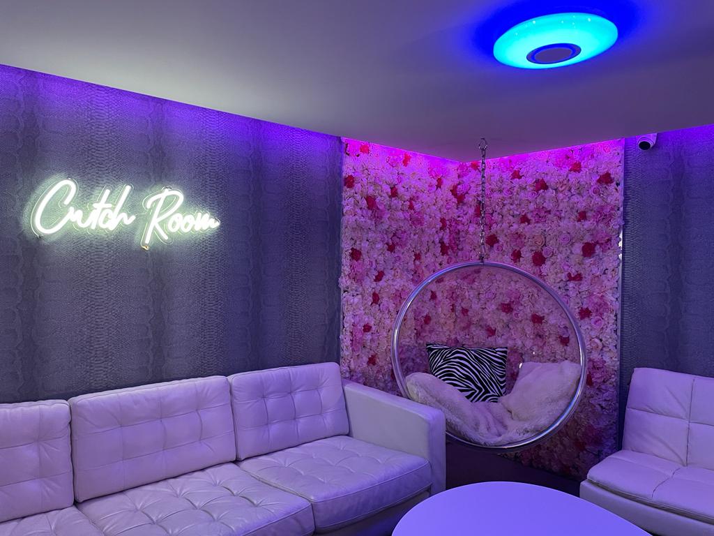 The Crutch Room private lounge with neon and floral wall