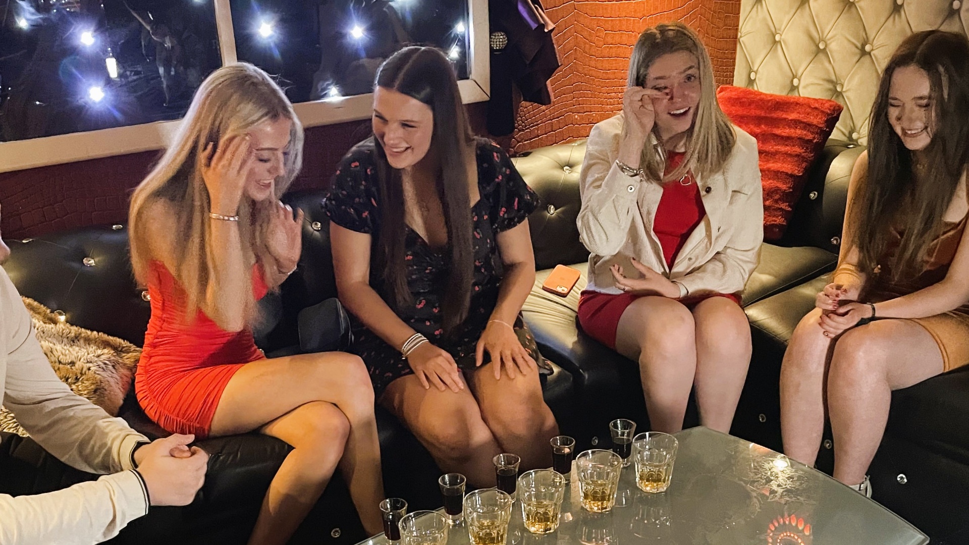 Friends sharing shots in a private booth